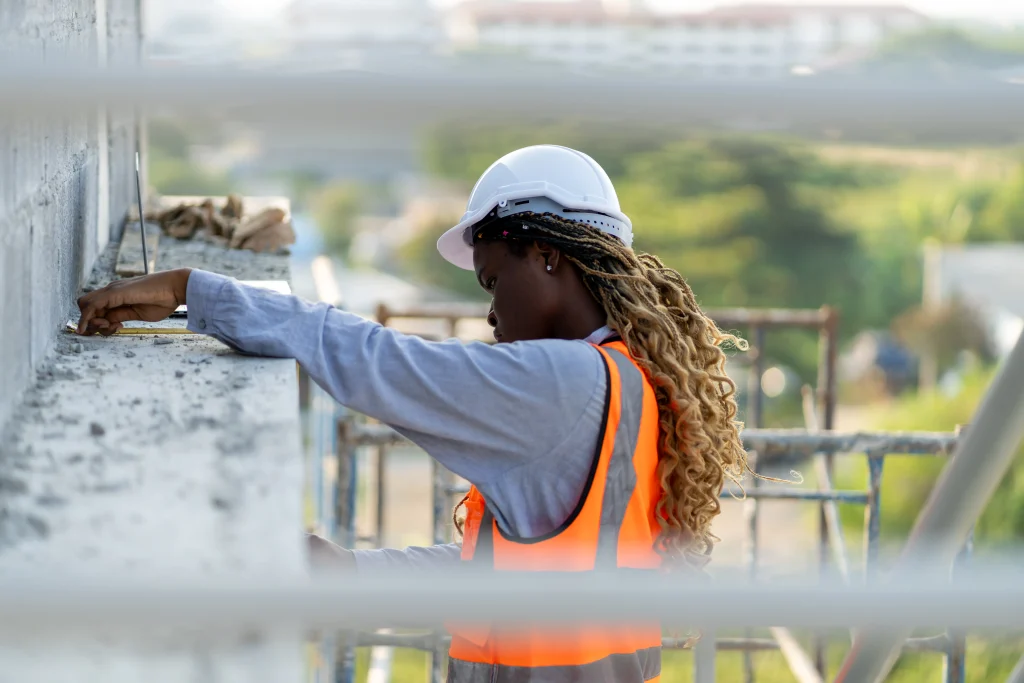 Engenheira fazendo medição em superfície de concreto durante obra