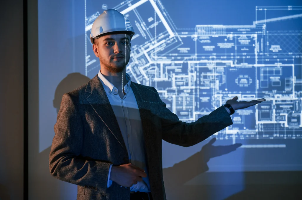 Engenheiro apresentando planta técnica projetada em tela